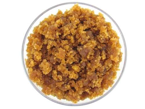 A glass bowl of JBHomemade Sugaring and Skin Care's Natural Almond Vanilla Brown Sugar Body Scrub.