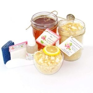 The bundle includes an 8 oz mason jar filled with soft sugaring wax, a jar of Coconut Lemon Sugar Body Scrub, a small bottle of pure aloe vera, a pouch of cornstarch, denim strips, an applicator, and a glass bowl showcasing the sugar scrub, garnished with coconut shavings and a slice of lemon.