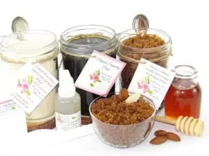 The bundle includes an 8 oz mason jar filled with firm sugaring paste, a jar of Almond Vanilla Brown Sugar Body Scrub, and Colloidal Oatmeal Brown Sugar Dry Body Scrub, a small bottle of pure aloe vera, a pouch of cornstarch, an applicator, and a glass bowl showcasing the sugar scrub, garnished with sprinkled almonds and a small glass jar of raw honey.