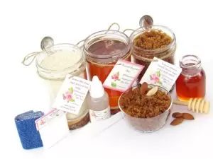 The bundle includes an 8 oz mason jar filled with soft sugaring wax, a jar of Almond Vanilla Brown Sugar Body Scrub, and Colloidal Oatmeal Brown Sugar Dry Body Scrub, a small bottle of pure aloe vera, a pouch of cornstarch, denim strips, an applicator, and a glass bowl showcasing the sugar scrub, garnished with sprinkled almonds and a small glass jar of raw honey.