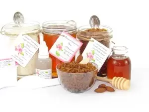 The bundle includes an 8 oz mason jar filled with soft sugaring wax, a jar of Almond Vanilla Brown Sugar Body Scrub, and Colloidal Oatmeal Brown Sugar Dry Body Scrub, a small bottle of pure aloe vera, a pouch of cornstarch, denim strips, an applicator, and a glass bowl showcasing the sugar scrub, garnished with sprinkled almonds and a small glass jar of raw honey.