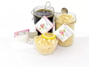 The bundle includes an 8 oz mason jar filled with firm sugaring paste, a jar of Coconut Lemon Sugar Body Scrub, a small bottle of pure aloe vera, a pouch of cornstarch, an applicator, and a glass bowl showcasing the sugar scrub, garnished with coconut shavings and a slice of lemon.