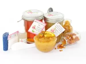 Natural Orange Calendula Herbal Citrus Sugar Scrub Sugaring Wax & Scrub Bundle – thinner hair A collection of skincare products including an 8 oz mason jar of sugaring wax and Orange Calendula Herbal Sugar Scrub, the included applicator, bottle of pure aloe vera, denims strips and accompanied by smaller jars of calendula petals and dried orange zest on a white background.