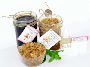 The bundle includes an 8 oz mason jar filled with firm sugaring paste, a jar of Peppermint Coconut Sugar Body Scrub, a small bottle of pure aloe vera, a pouch of cornstarch, an applicator, and a glass bowl showcasing the sugar scrub, garnished with coconut shavings and a sprig of fresh mint.
