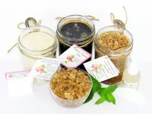 The bundle includes an 8 oz mason jar filled with firm sugaring paste, a jar of Peppermint Coconut Sugar Body Scrub, and Colloidal Oatmeal Brown Sugar Dry Body Scrub, a small bottle of pure aloe vera, a pouch of cornstarch, an applicator, and a glass bowl showcasing the sugar scrub, garnished with coconut shavings and a sprig of fresh mint.
