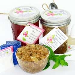 The bundle includes an 8 oz mason jar filled with soft sugaring wax, a jar of Peppermint Coconut Sugar Body Scrub, a small bottle of pure aloe vera, a pouch of cornstarch, denim strips, an applicator, and a glass bowl showcasing the sugar scrub, garnished with coconut shavings and a sprig of fresh mint.