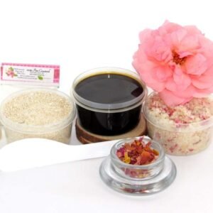 The home sugaring hair removal starter kit comes with a 2 oz tub of firm sugaring paste, a tub of Pink Rose Petal Sugar Body Scrub, and a tub of Colloidal Oatmeal Brown Sugar Dry Body Scrub, a small bottle of pure aloe vera, a pouch of cornstarch, an applicator, and a glass bowl garnished with a pink rose bloom.