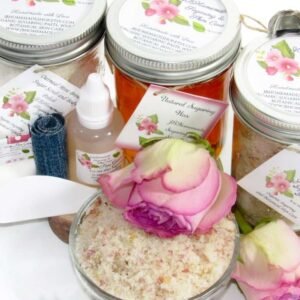 The bundle includes an 8 oz mason jar filled with soft sugaring wax, a jar of Pink Rose Petal Sugar Body Scrub, and Colloidal Oatmeal Brown Sugar Dry Body Scrub, a small bottle of pure aloe vera, a pouch of cornstarch, denim strips, an applicator, and a glass bowl showcasing the sugar scrub, garnished with a pink rose bloom.