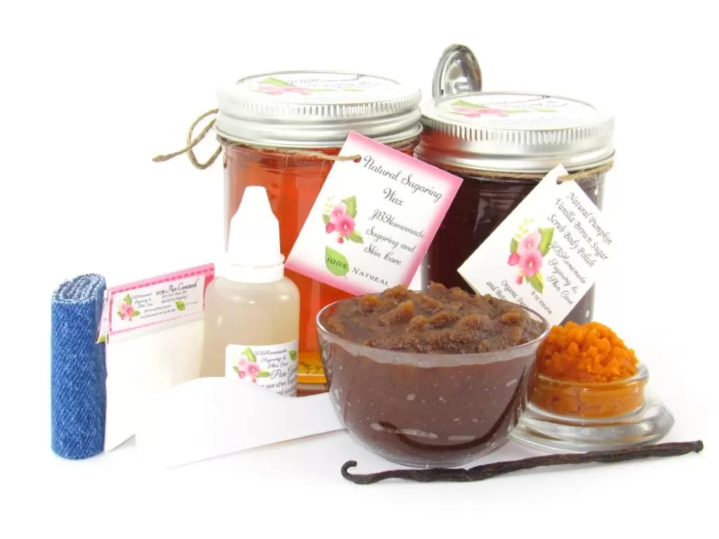 The bundle includes an 8 oz mason jar filled with soft sugaring wax, a jar of Pumpkin Vanilla Brown Sugar Body Scrub, a small bottle of pure aloe vera, a pouch of cornstarch, denim strips, an applicator, and a glass bowl showcasing the sugar scrub, garnished with a vanilla bean and pumpkin puree.