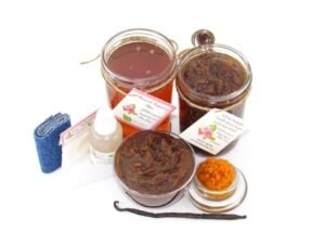The bundle includes an 8 oz mason jar filled with soft sugaring wax, a jar of Pumpkin Vanilla Brown Sugar Body Scrub, a small bottle of pure aloe vera, a pouch of cornstarch, denim strips, an applicator, and a glass bowl showcasing the sugar scrub, garnished with a vanilla bean and pumpkin puree.
