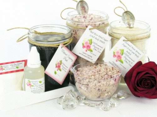 The bundle includes an 8 oz mason jar filled with firm sugaring paste, a jar of Red Rose Petal Sugar Body Scrub, and Colloidal Oatmeal Brown Sugar Dry Body Scrub, a small bottle of pure aloe vera, a pouch of cornstarch, an applicator, and a glass bowl showcasing the sugar scrub, garnished with a red rose bloom.