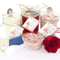 The bundle includes an 8 oz mason jar filled with soft sugaring wax, a jar of Red Rose Petal Sugar Body Scrub, and Colloidal Oatmeal Brown Sugar Dry Body Scrub, a small bottle of pure aloe vera, a pouch of cornstarch, denim strips, an applicator, and a glass bowl showcasing the sugar scrub, garnished with a red rose bloom.