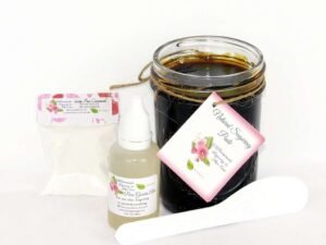 An 8-ounce mason of JBHomemade Sugaring Paste is presented with its included pouch of cornstarch, bottle of aloe vera and applicator.