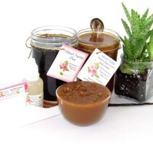 The bundle includes an 8 oz mason jar filled with firm sugaring paste, a jar of Vanilla Aloe Brown Sugar Body Scrub, a small bottle of pure aloe vera, a pouch of cornstarch, an applicator, and a glass bowl showcasing the sugar scrub, garnished with a vanilla bean and a glass planter with an aloe plant to the right.