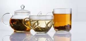 Various types of floral infusion teas on a white reflective table.