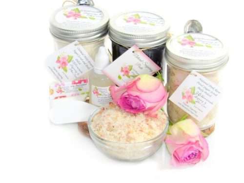The bundle includes an 8 oz mason jar filled with firm sugaring paste, a jar of Pink Rose Petal Sugar Body Scrub, and Colloidal Oatmeal Brown Sugar Dry Body Scrub, a small bottle of pure aloe vera, a pouch of cornstarch, an applicator, and a glass bowl showcasing the sugar scrub, garnished with a pink rose bloom.