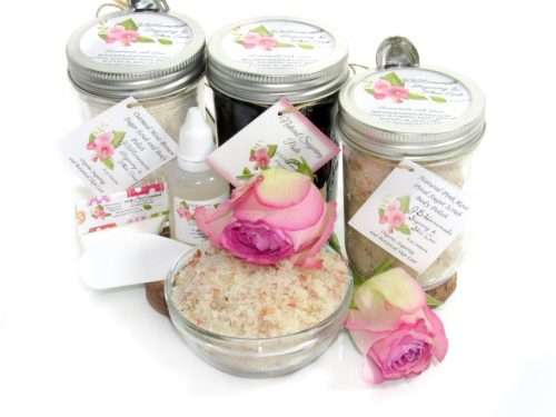 The bundle includes an 8 oz mason jar filled with firm sugaring paste, a jar of Pink Rose Petal Sugar Body Scrub, and Colloidal Oatmeal Brown Sugar Dry Body Scrub, a small bottle of pure aloe vera, a pouch of cornstarch, an applicator, and a glass bowl showcasing the sugar scrub, garnished with a pink rose bloom.