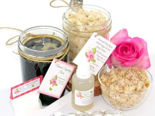 The bundle includes an 8 oz mason jar filled with firm sugaring paste, a jar of Pink Rose Petal Sugar Body Scrub, a small bottle of pure aloe vera, a pouch of cornstarch, an applicator, and a glass bowl showcasing the sugar scrub, garnished with a pink rose bloom.