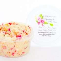 Explore the delicate 2 oz tub of soft pink rose petal cane sugar scrub, gently scented and perfect for pampering your skin.