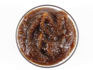 A glass bowl of JBHomemade Sugaring and Skin Care's Natural Pumpkin Vanilla Brown Sugar Body Scrub.