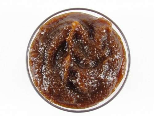 A glass bowl of JBHomemade Sugaring and Skin Care's Natural Pumpkin Vanilla Brown Sugar Body Scrub.