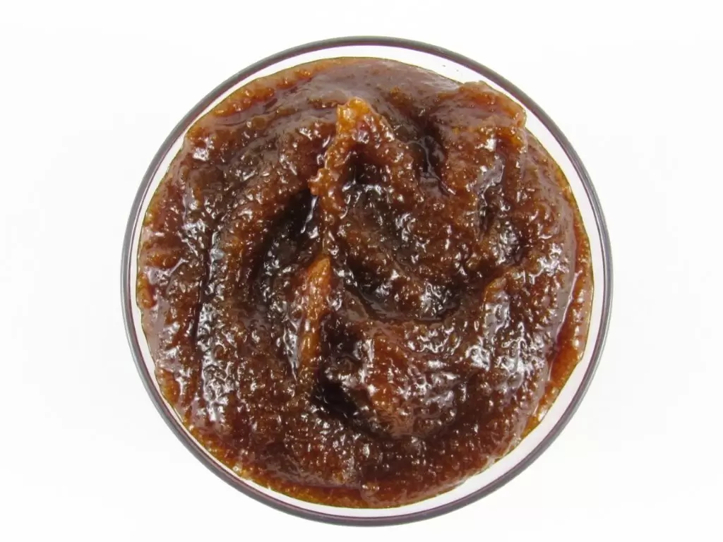 A glass bowl of JBHomemade Sugaring and Skin Care's Natural Pumpkin Vanilla Brown Sugar Body Scrub.