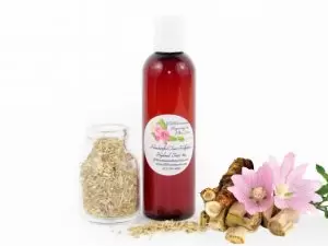 JBHomemade Hollyhock Hydrosol Toner 4 oz A bottle of JBHomemade’s handcrafted hollyhock water toner, made with organic marshmallow root and fresh hollyhock blooms, accompanied by dried marshmallow root and a vibrant hollyhock flower.