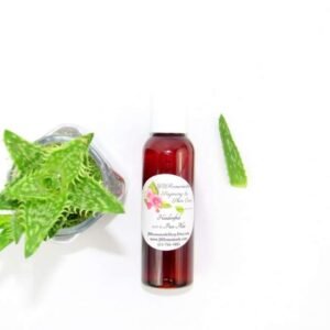 A 2 oz amber bottle of Pure Aloe Vera product, enriched and authentic, surrounded by fresh aloe vera leaf pieces, showcasing the natural ingredients and the premium quality of the product.