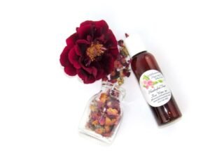 An overhead perspective of a 2 oz bottle of handcrafted rose water with natural ingredients visible.
