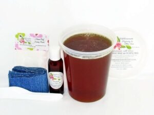 A 32 oz tub of JBHomemade Sugaring Wax is presented with its included large pouch of cornstarch, denim strips and arrowroot powder, bottle of aloe vera and applicators.