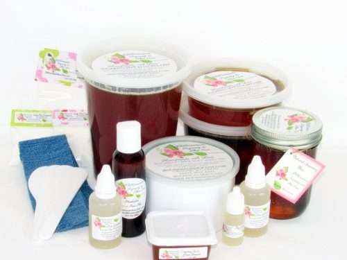 A variety of JBHomemade sugaring wax containers, pure aloe vera bottles, cornstarch pouches, applicators, and denim strips for complete skin care. The image showcases a collection of JBHomemade Sugaring Wax in various container sizes including tubs and masons alongside bottles of pure garden-fresh aloe vera, pouches of cornstarch, applicators, and denim strips arranged aesthetically against a white background. The assortment includes 16 Oz (two half pint masons), 16 Oz Tub, 24 Oz (3 half pink masons), 2 Oz tub, 32 Oz tub, a 400g Tin, 8 Oz mason, and an 8 oz tub. The aloe vera bottles provide soothing aftercare, while the cornstarch pouches are used for skin preparation. Applicators and denim strips complete this comprehensive collection for effective and natural hair removal. 🌸