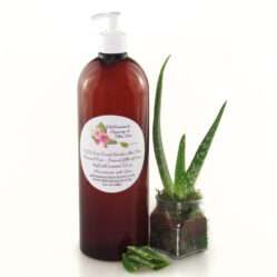 A 32 oz amber pump bottle of Pure Aloe Vera product, enriched and authentic, surrounded by fresh aloe vera leaf pieces, showcasing the natural ingredients and the premium quality of the product.
