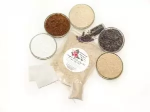 An 8 oz zip pouch of JBHomemade’s Lavender Oatmeal Bath Soak, A selection of natural ingredients including whole oats, brown sugar, colloidal oatmeal, baking soda, and lavender displayed in separate bowls to highlight their purity and quality.