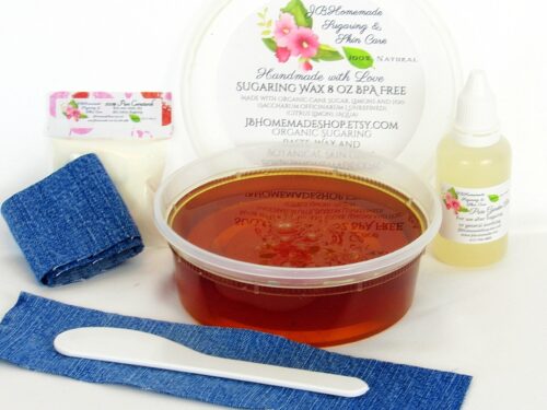 An 8-ounce tub of JBHomemade Sugaring Wax is presented with its included pouch of cornstarch, bottle of aloe vera, denim strips and applicator.
