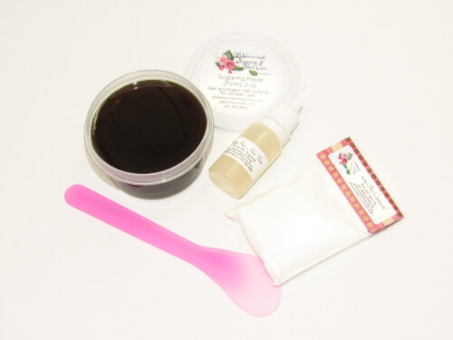 A 2-ounce tub of JBHomemade Sugaring Paste is presented with its included pouch of cornstarch, bottle of aloe vera and applicator.