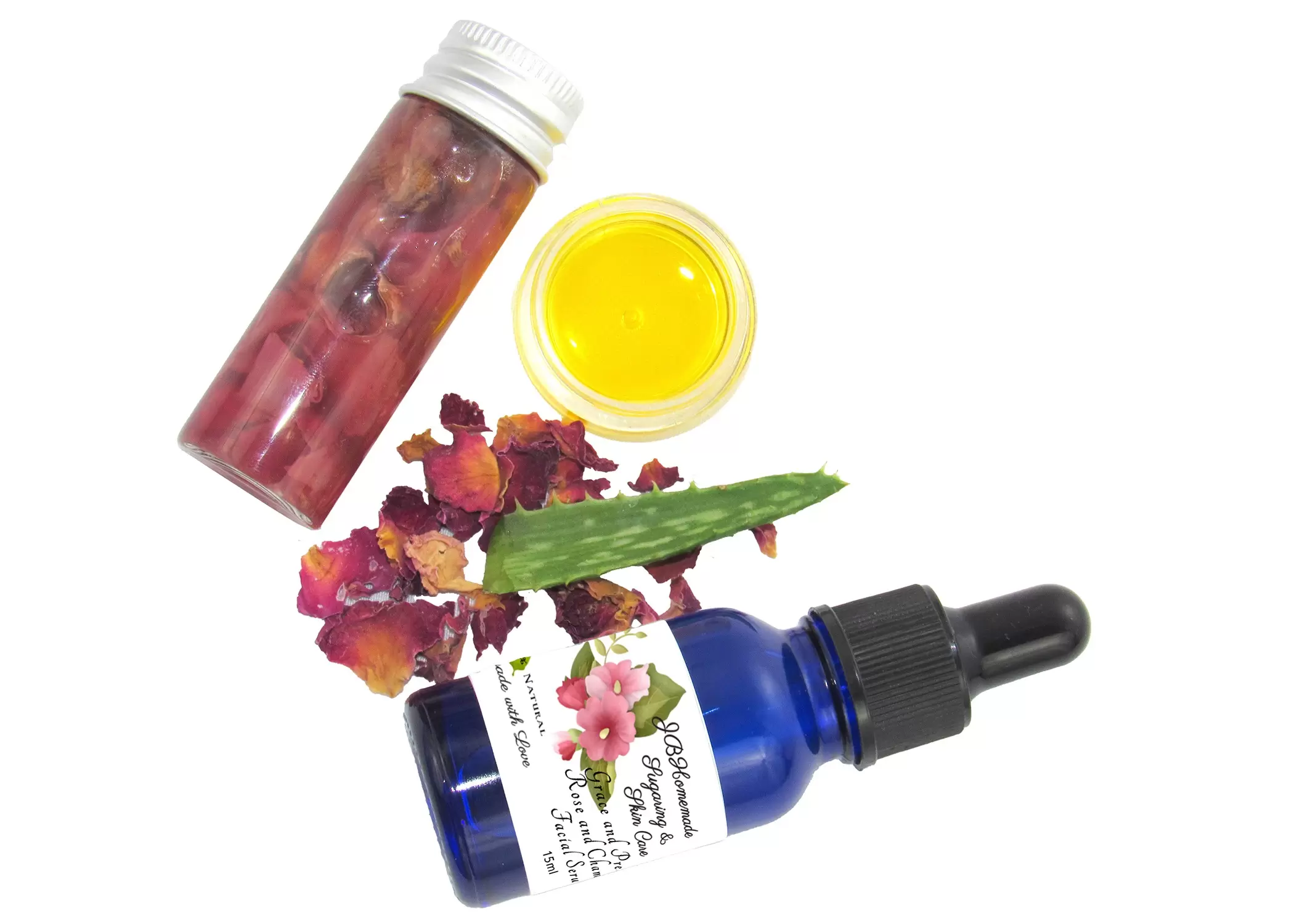 An elegant display of the facial serum, rose-infused aloe vera, and infused grapeseed oil surrounded by nature’s touch of dried roses and an aloe leaf.