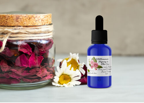 A blue bottle of Grace and Presence Rose and Chamomile Facial Serum, dried red rose petals in a glass jar, and dried chamomile flowers against a neutral background.