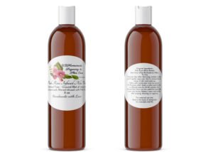 A pair of JBHomemade Sugaring and Skin Care's Radiant Rose Glow Pink Rose infused Pure Aloe Vera 8 oz amber bottles on a white background. The bottle on the left displays the front label, while the bottle on the right shows the back label. The back label lists the pure ingredients, usage and care instructions, and shelf life of the product.