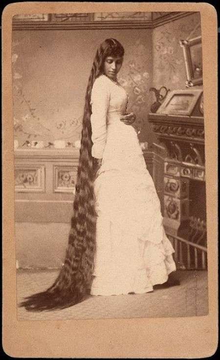 Victorian era woman with long hair touching the floor, signifying status and femininity