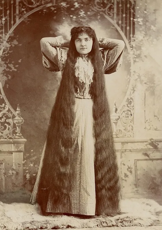 Victorian era woman with long hair touching the floor, signifying status and femininity
