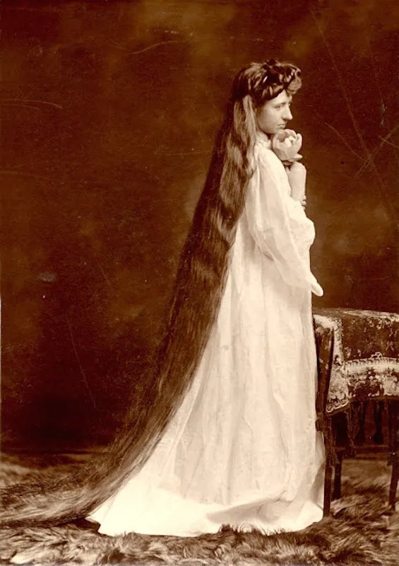 Victorian era woman with long hair touching the floor, signifying status and femininity